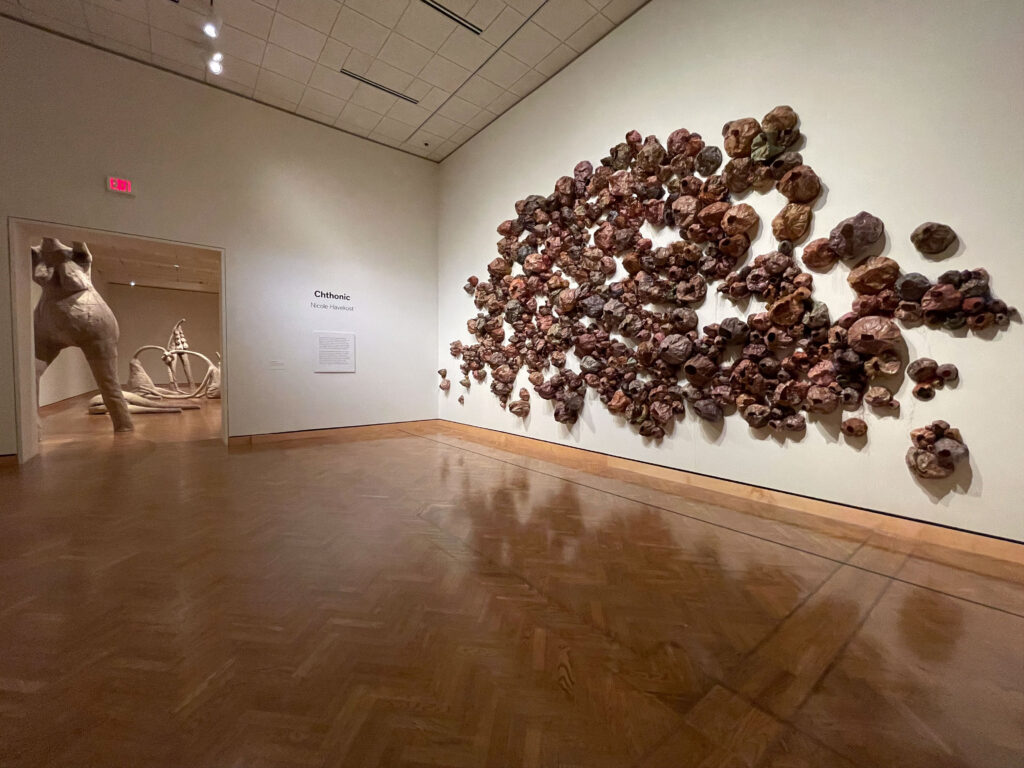 Gallery entrance with brown sculptures on a white wall