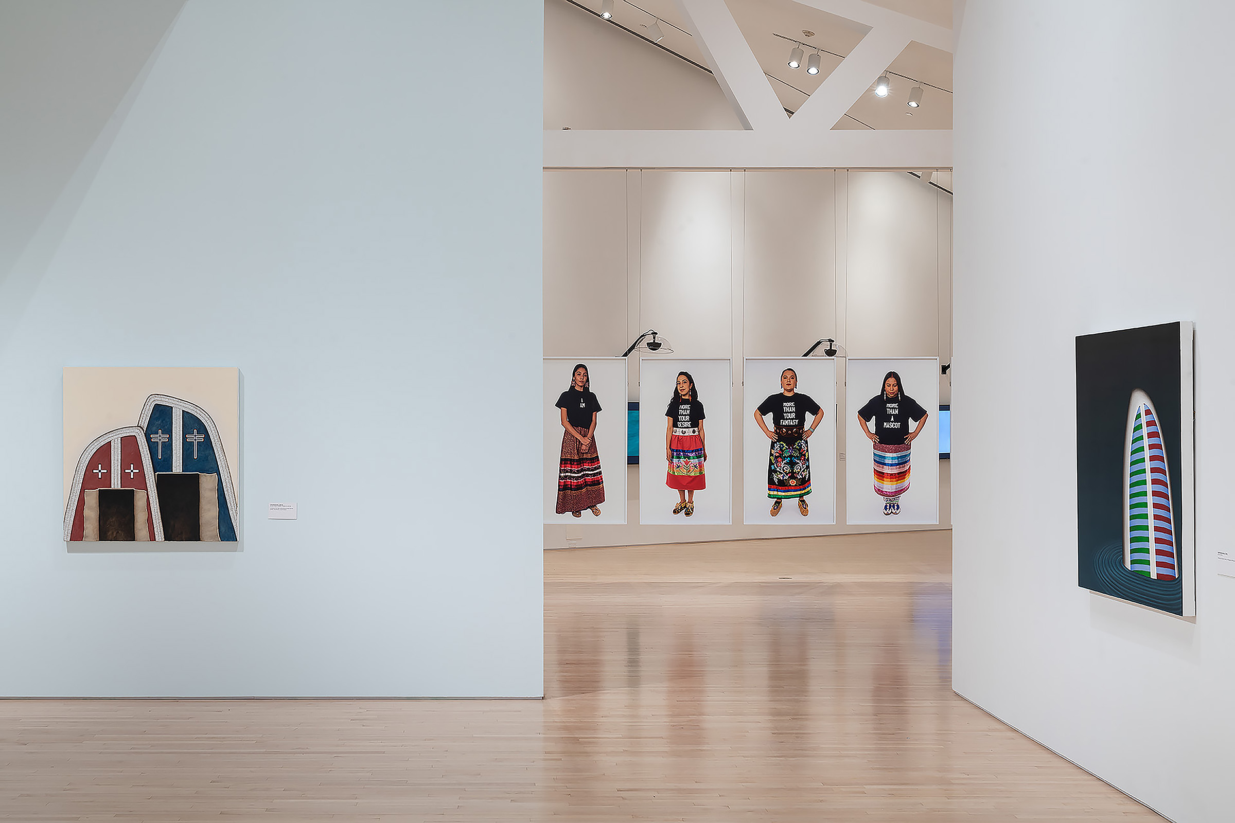 Open doorway in white-walled gallery, with abstract and figurative paintings.