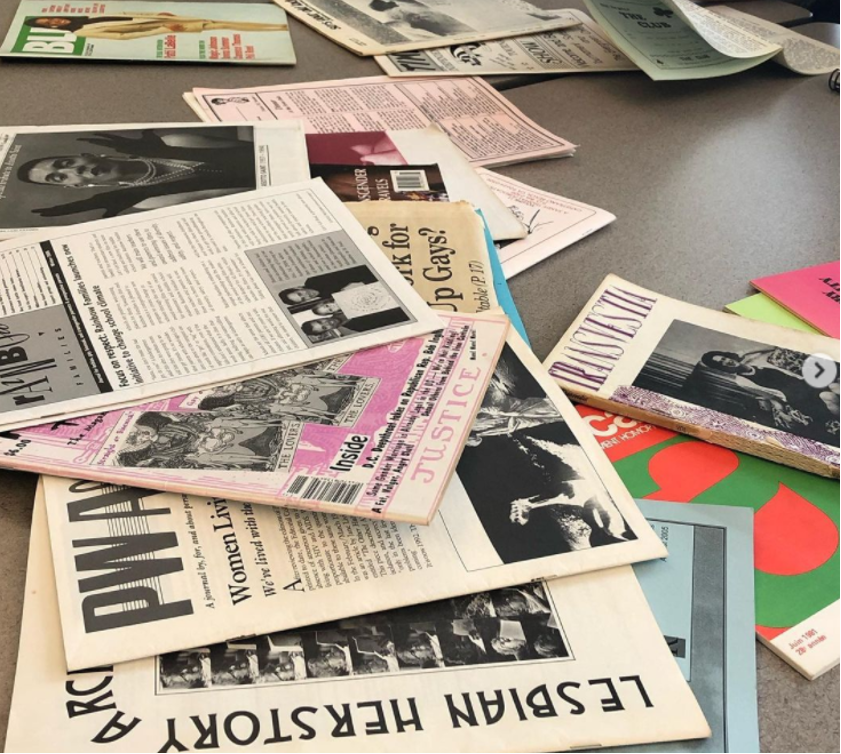 Collection of newspapers and zines, with a headline reading: LESBIAN HERSTORY.