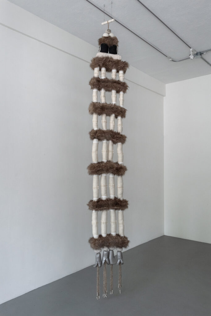 Brown and white hanging fiber sculpture.