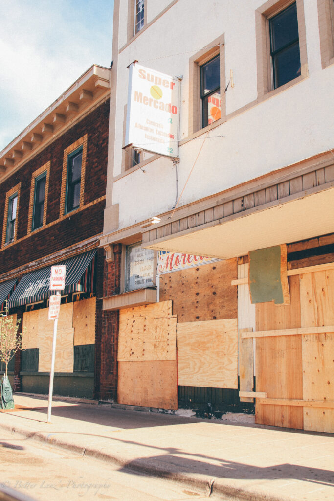 Plywood boards cover storefronts.