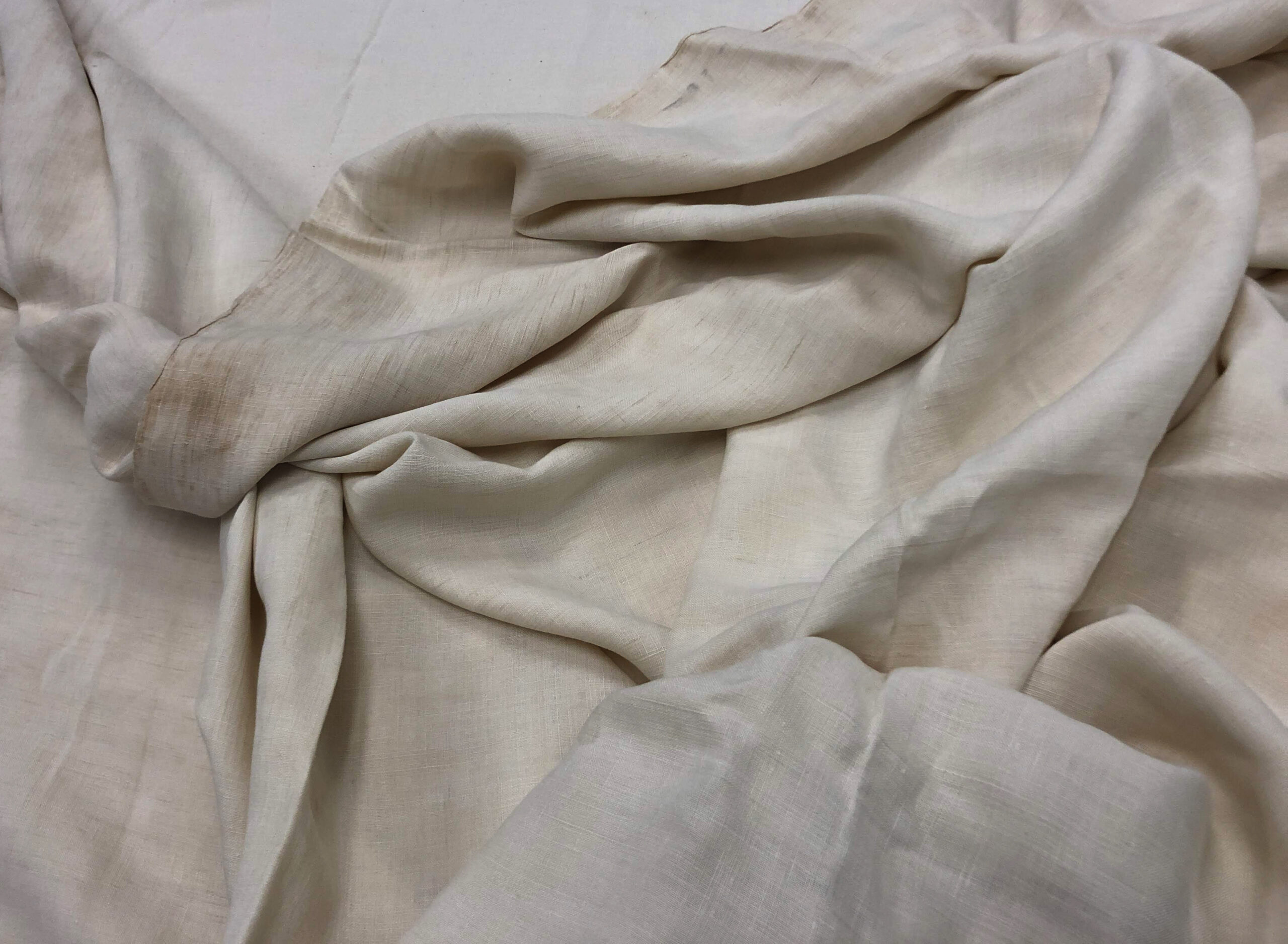 Loosely folded off-white textile.