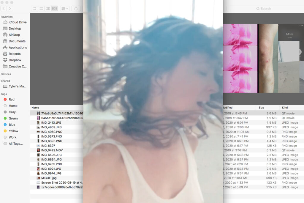 Many windows open on computer desktop, in the center a person with long brown hair turning their head away from the camera.