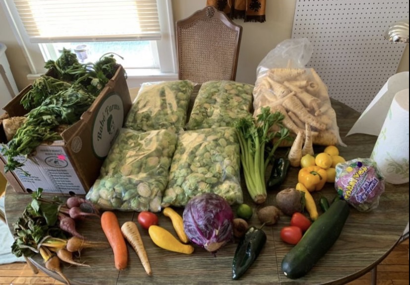 Large pile of raw vegetables, including many bags of brussels sprouts, parsnips, squash, and celery.