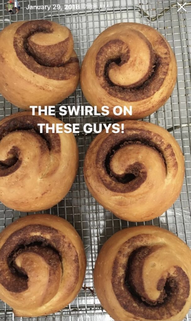 Cinnamon rolls viewed from above, with text overlay reading THE SWIRLS ON THESE GUYS!