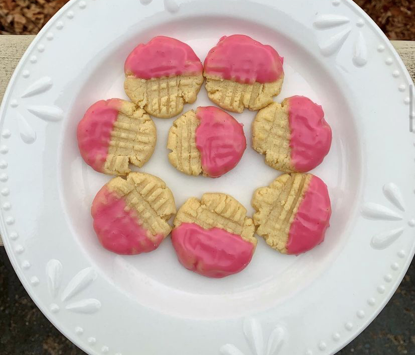 White plate with light-colored cookies, dipped in pink.