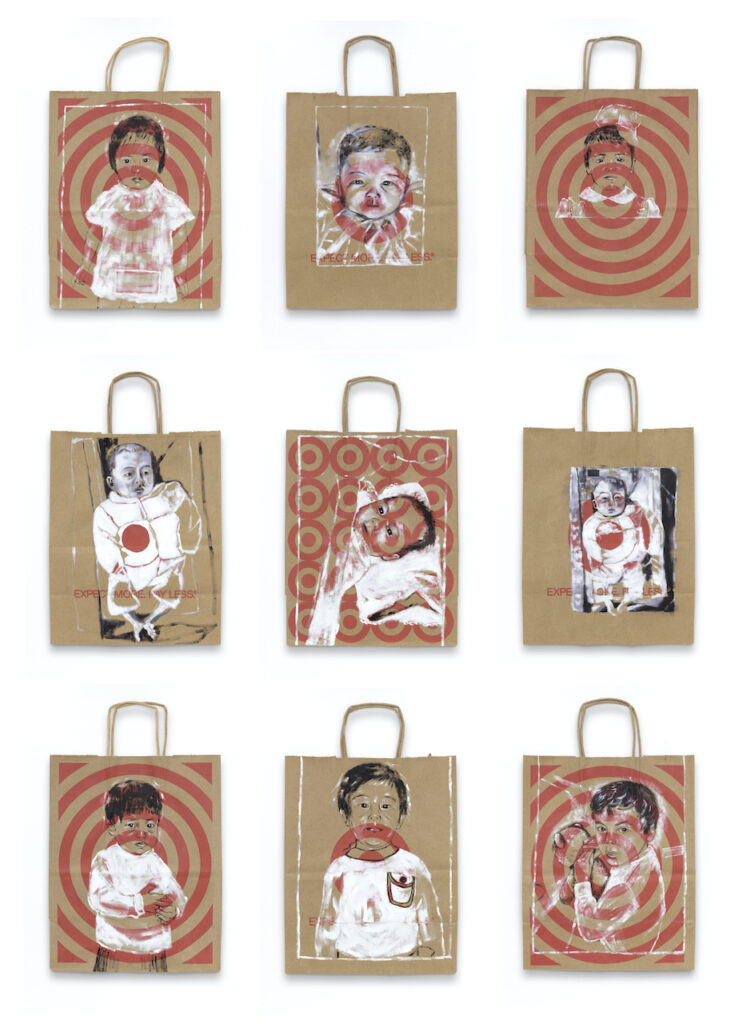 Twelve portraits of infants and children painted on brown shopping bags with red Target logos.