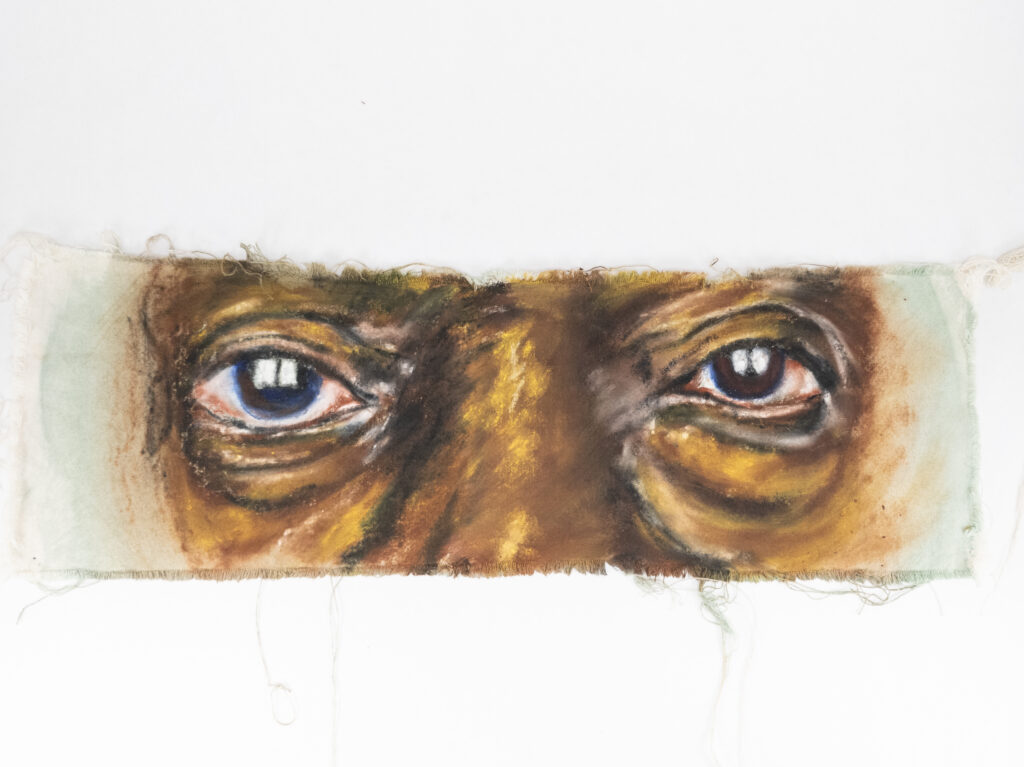 Long painting of eyes that look directly at viewer, with wrinkles on dark skin.