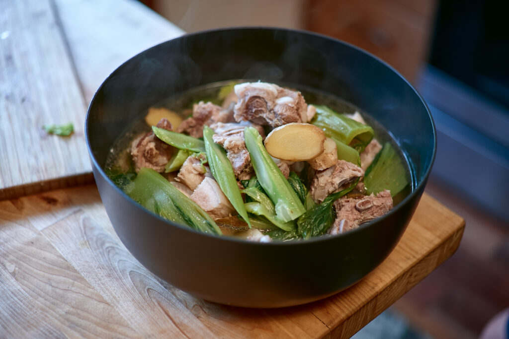 Steaming bowl of boiled pork and Hmong greens.