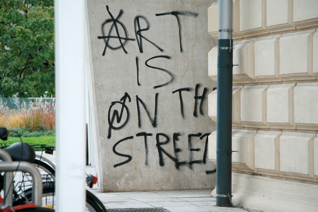 Graffiti on concrete building reads: "ART IS ON THE STREET."