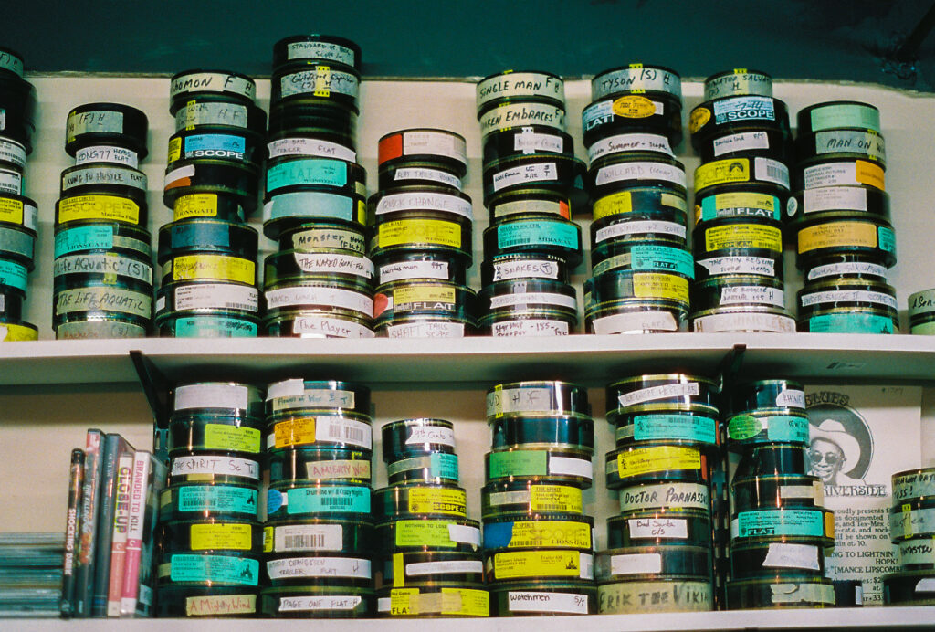 Shelves with stacks of film reels marked with colored tape.