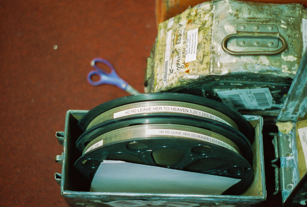Reels of film with labels and scissors on floor.