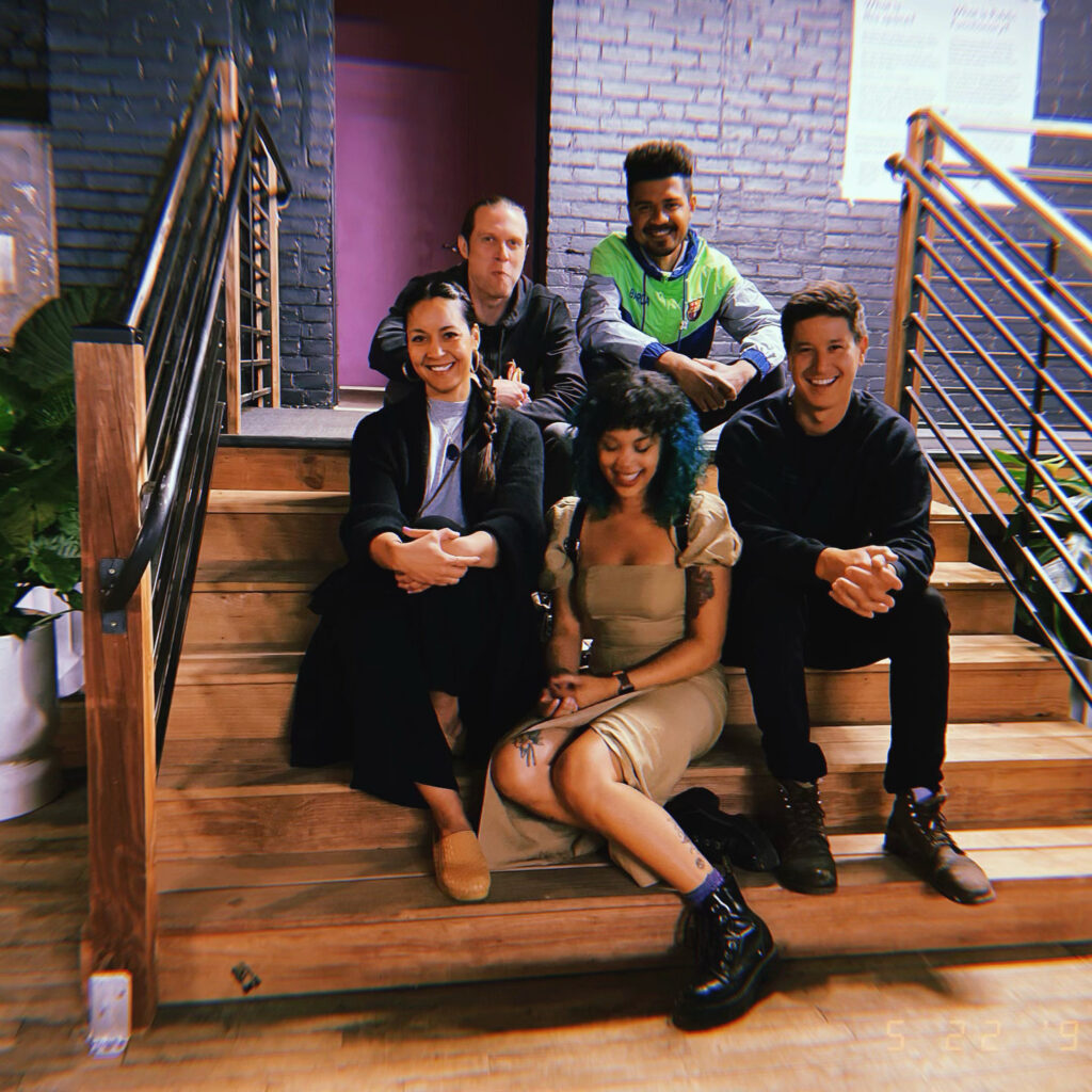 A group of people sit on a staircase smiling.