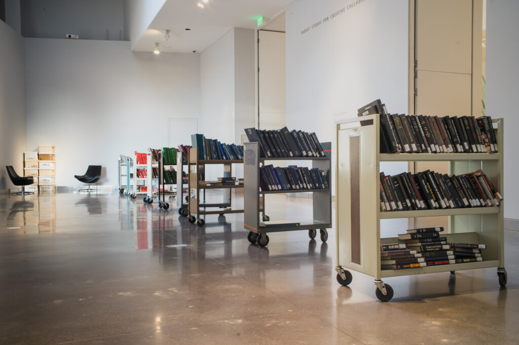 Gallery filled with rolling library carts filled with books.