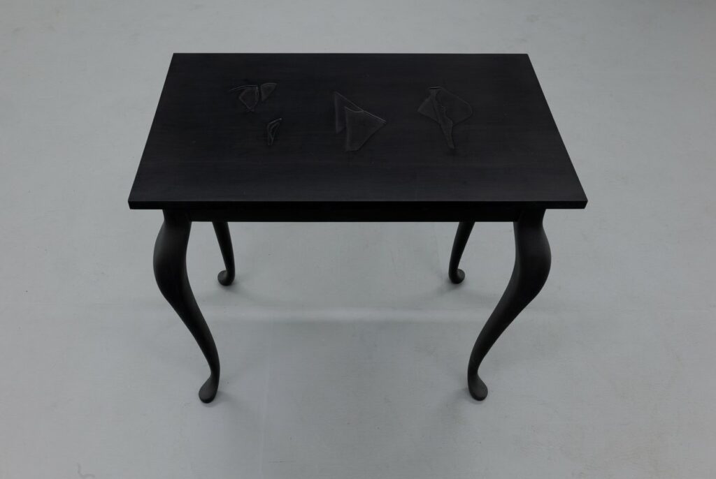 A small black table with cabriole-style legs