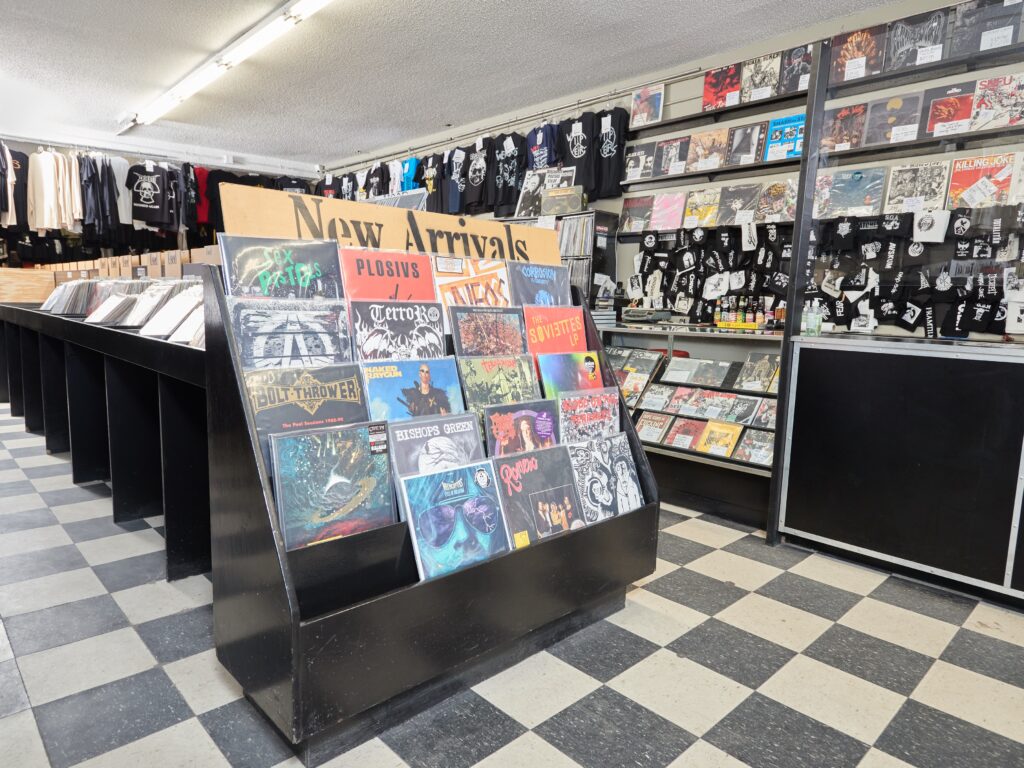 Interior of record store with black and white tile floor and displaying reading "New Arrivals".