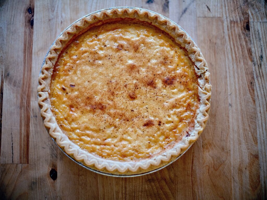 Custardy yellow pie on light wood surface.