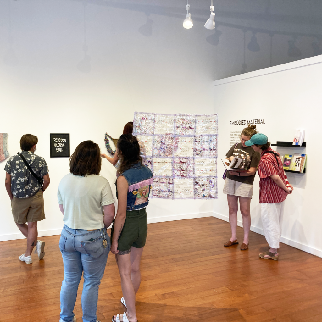 People look at art on gallery walls.