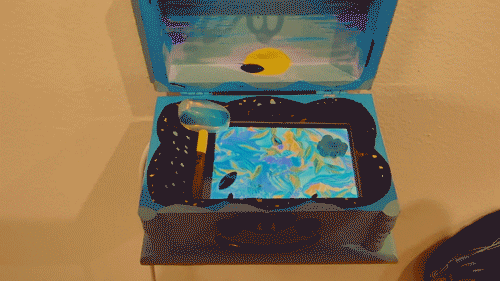 Painted wooden box with small screen playing inside