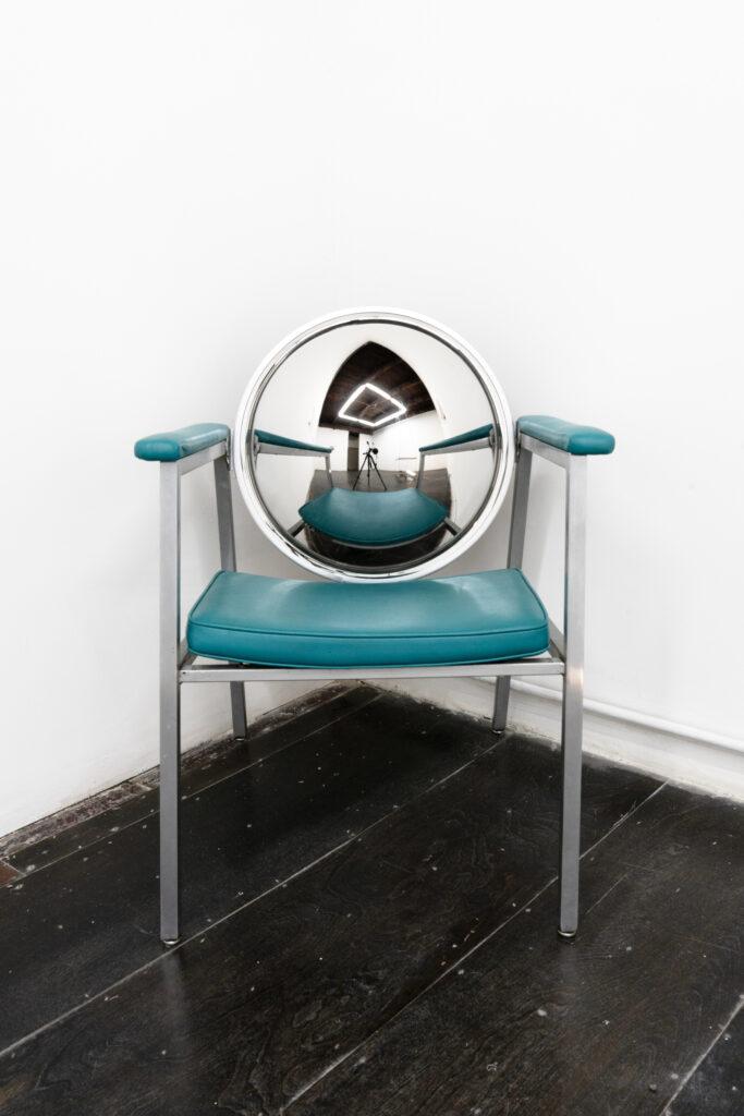 Chair in corner with mirrored security dome as backrest