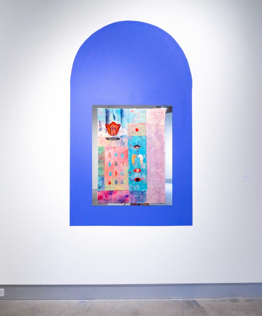 Blue arch painted on wall with hand stitched tapestry mounted on top