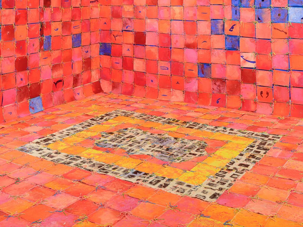 Space with tiles of dyed cloth sewn together covering walls and floor