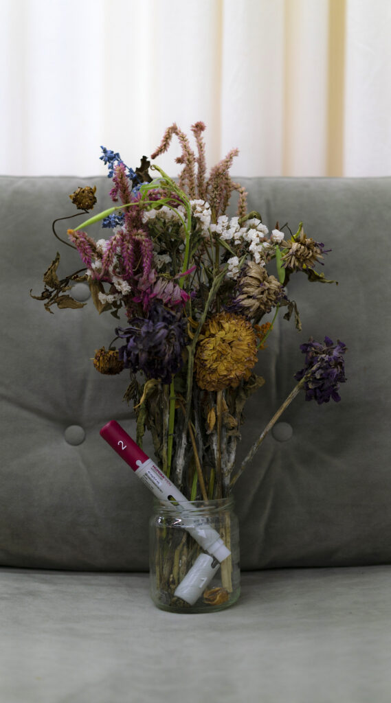 Vase of dying flowers and medication