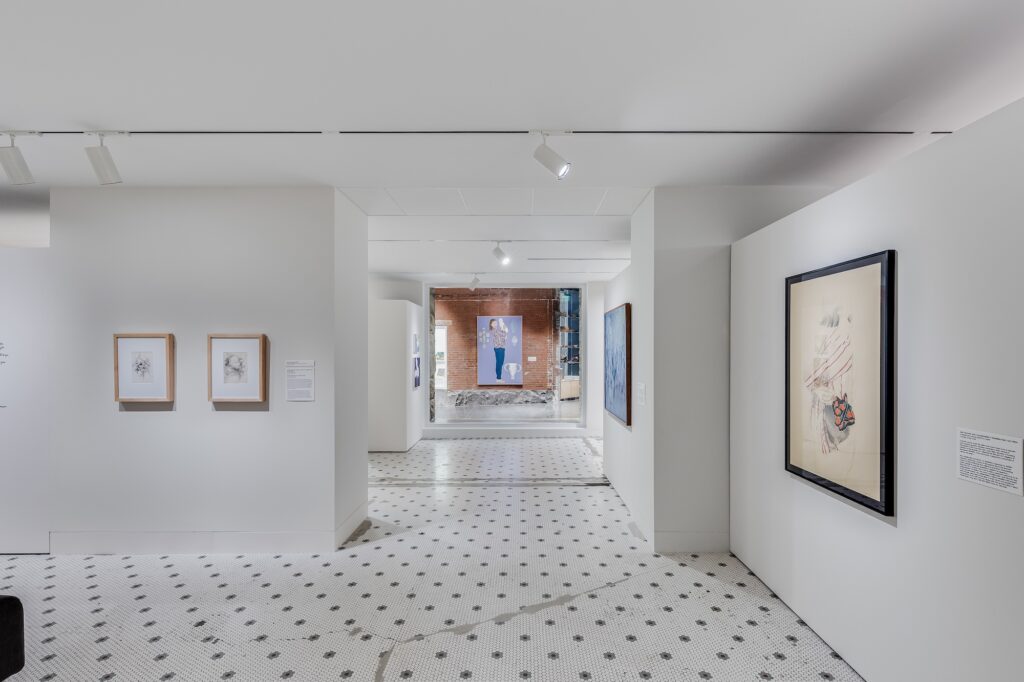 White gallery space with tile floors and artwork hung on walls with large painting of person down the hall