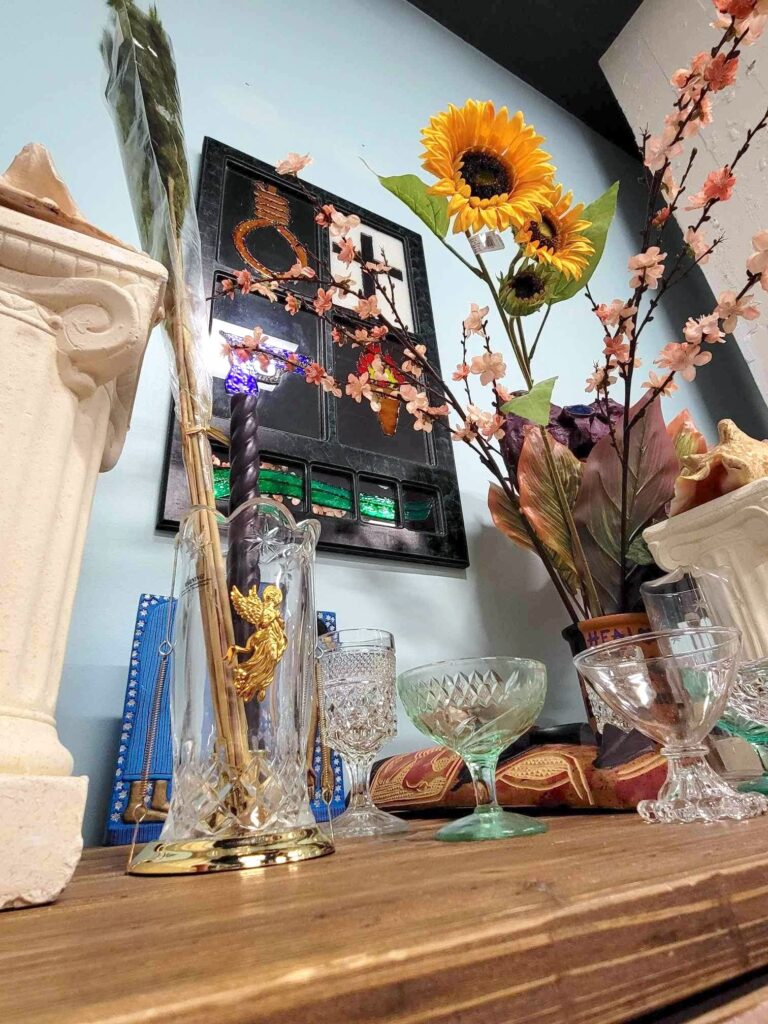 Altar with glasses, flowers, images of the cross, masks, columns.