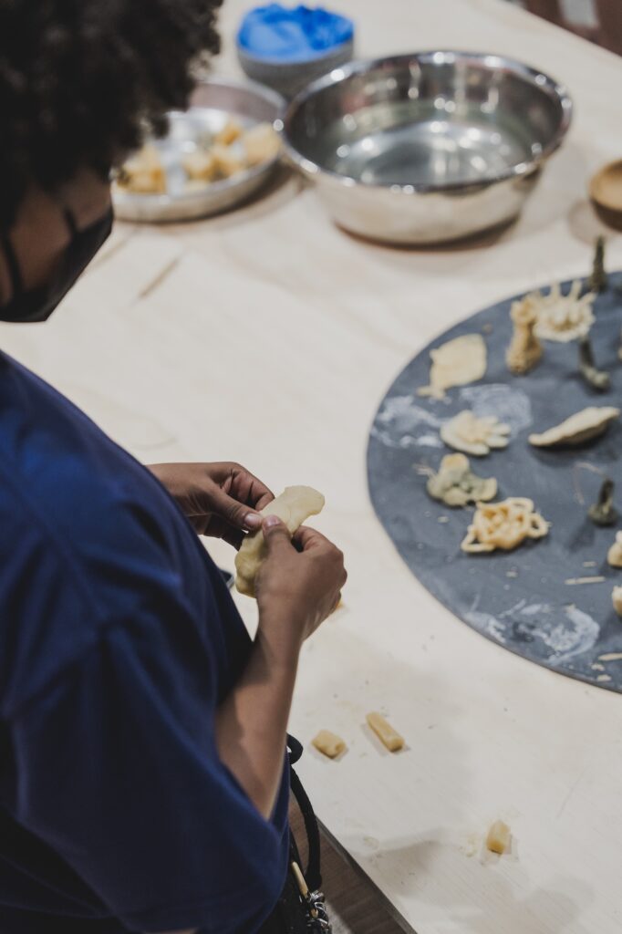 Close-up of artist molding an object in their hand.