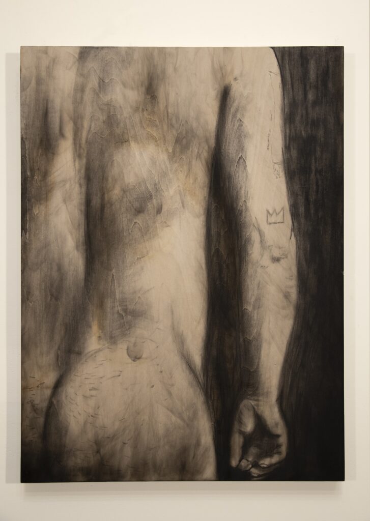 Charcoal drawing on wood panel of person's nude back torso and right arm