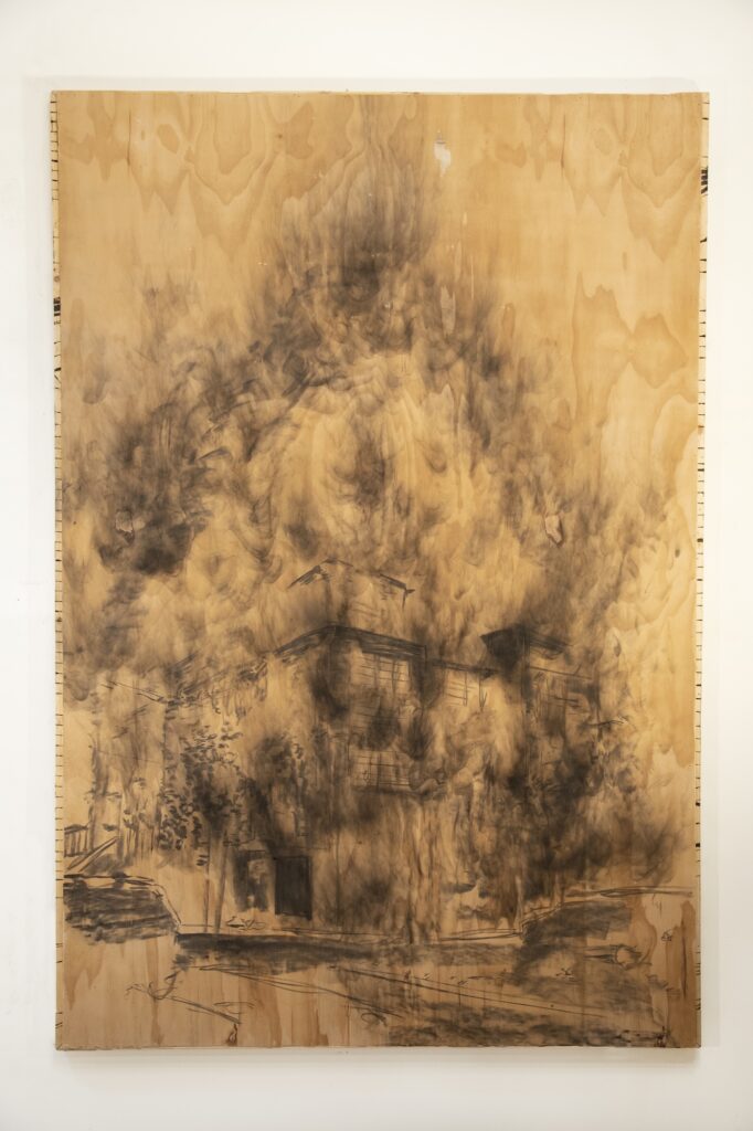 Charcoal drawing on plywood panel of building engulfed in smoke